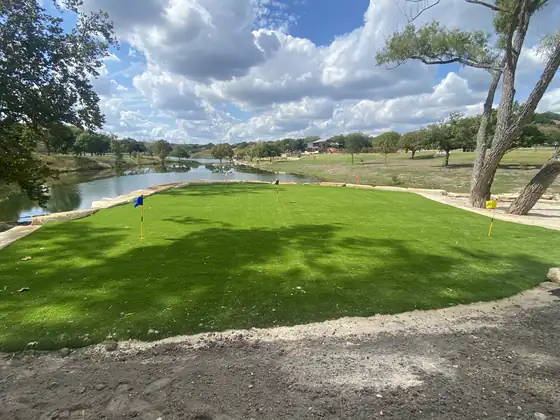 Open artificial turf area overlooking a lake