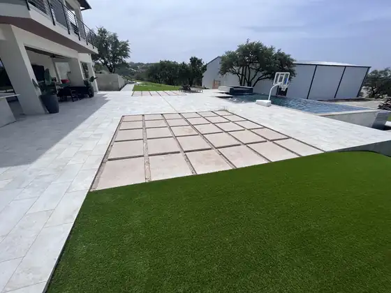 Artificial turf installed next to a paver patio